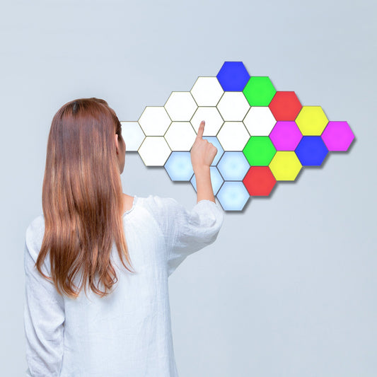 Woman shown from behind, interacting with Touch Sensitive Honeycomb Modular Wall Lights on the wall in front of her.