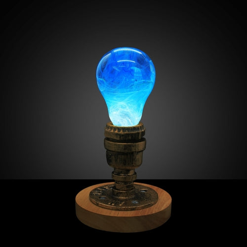 Illuminated clear lightbulb filled with blue swirls, set in vintage copper and wooden base in darkened room.