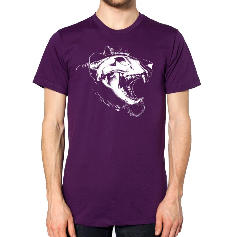 Man in purple short sleeve tee shirt, printed with white graphic showing an x-ray style image of a lion’s head and skull.